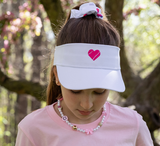 White tennis visor with hot pink embroidered heart on front from  Love Set Match tennis wear